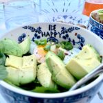 sliced green fruit on white and blue ceramic bowl