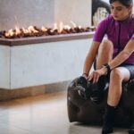woman in purple crew neck t-shirt and black shorts sitting on white floor