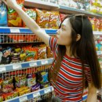 woman standing while grabbing plastic pack