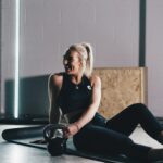 woman in black tank top and black leggings sitting on black chair