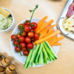 slices of carrots, zucchini, and cherry tomatoes on round white ceramic bowl