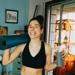 woman in black sports bra holding blue and black kettle