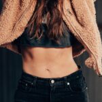 woman in black denim jeans and brown fleece coat