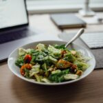 salad on white ceramic bowl on top of table near laptop