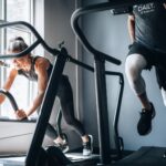 woman in black tank top and black shorts sitting on black exercise equipment