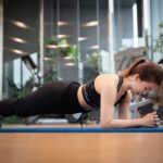 a woman is doing push ups on a blue mat
